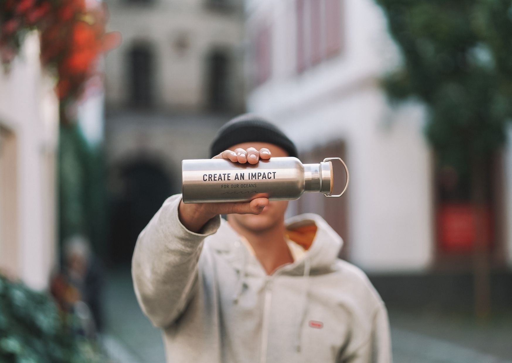 Mann zeigt mit GOT BAG Flasche mit Aufschrift Create an Impact